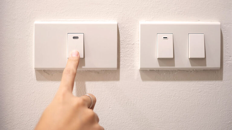 Mulher desligando interruptor de luz
